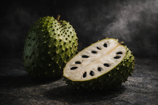 Soursop fruit (Annona muricata) whole and sliced showing white flesh and black seeds, used to discuss soursop side effects and safety